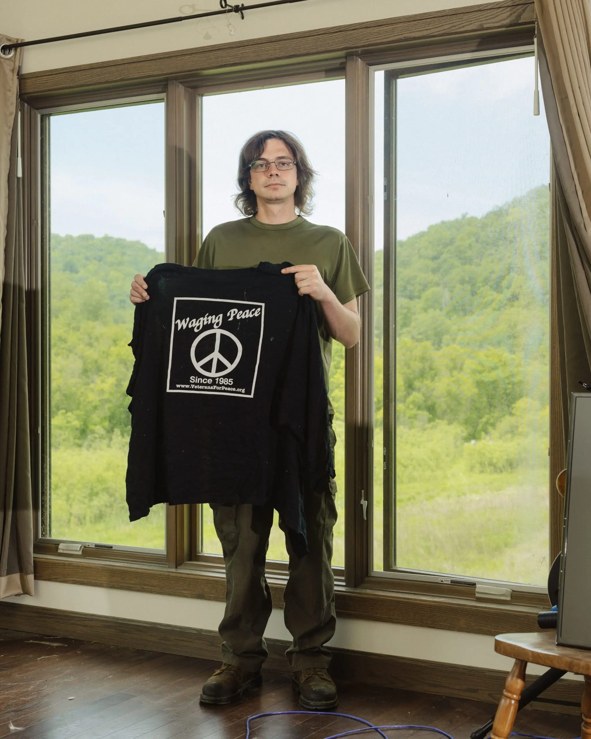 Author 1 displays the “Veterans for Peace” shirt he was wearing when police shot him in the head with a bean-bag round.