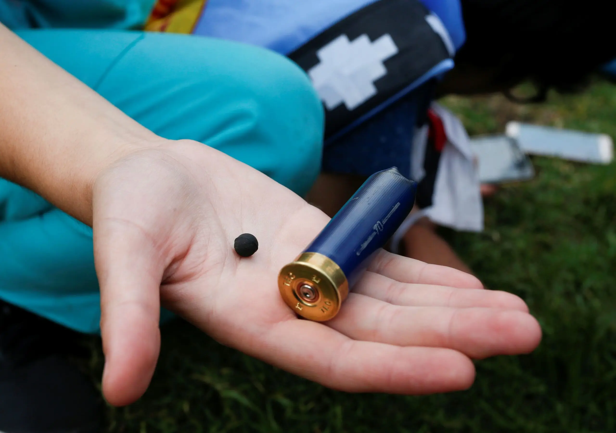 A protester displays a pellet and a spent casing that they are fired from.